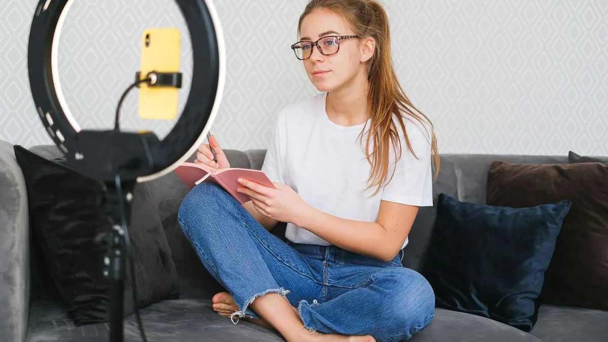 Ring light yanında kitap okuyan içerik üreticisi