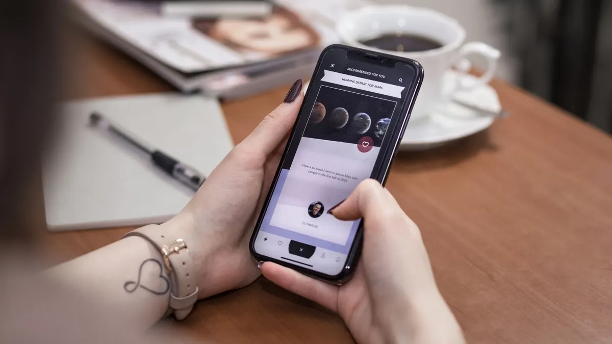 Elinde telefon tutan kişinin ekrandaki sosyal medya uygulamasını incelemesi