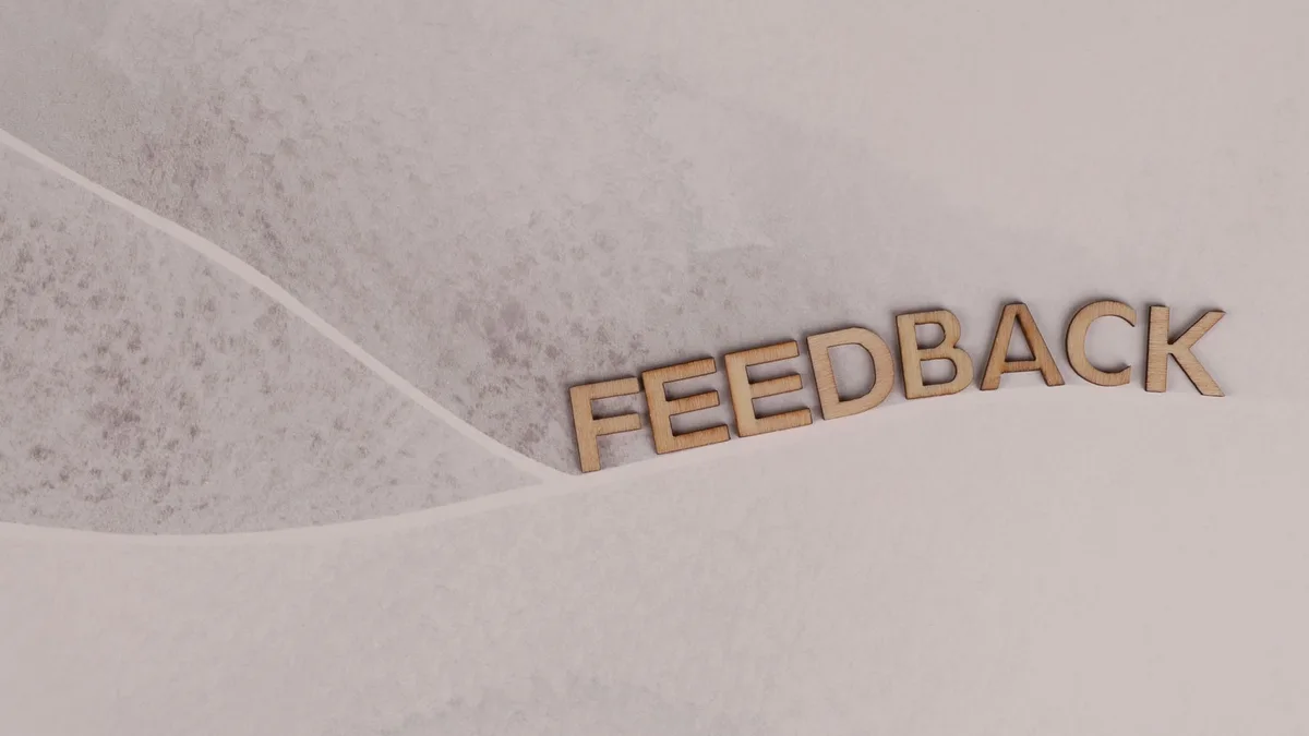 Kâğıt üzerinde feedback yazan ahşap harfler