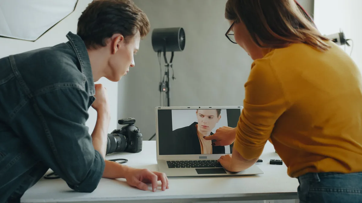 Stüdyoda ekrandaki portre fotoğrafını birlikte inceleyen iki kişi