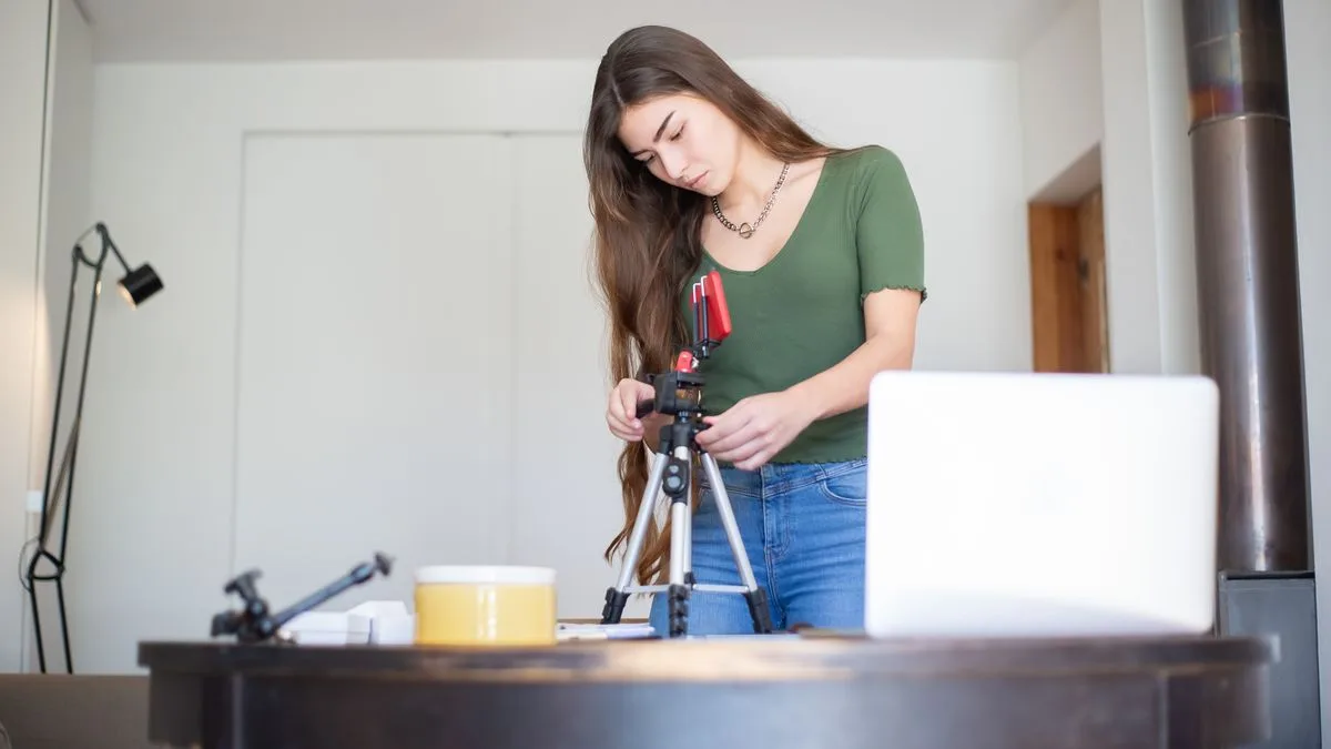 Ev stüdyosunda tripod ve kamera hazırlayan içerik üreticisi