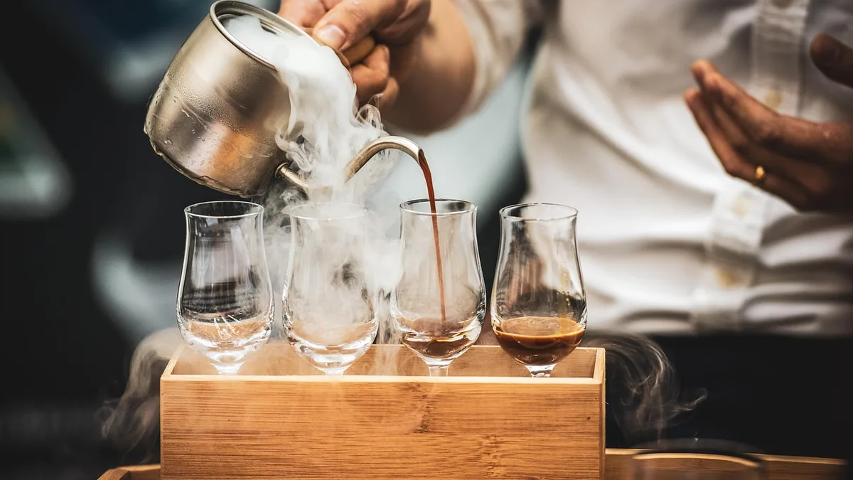 Kafede sürahiyle fincana içecek hazırlayan barista