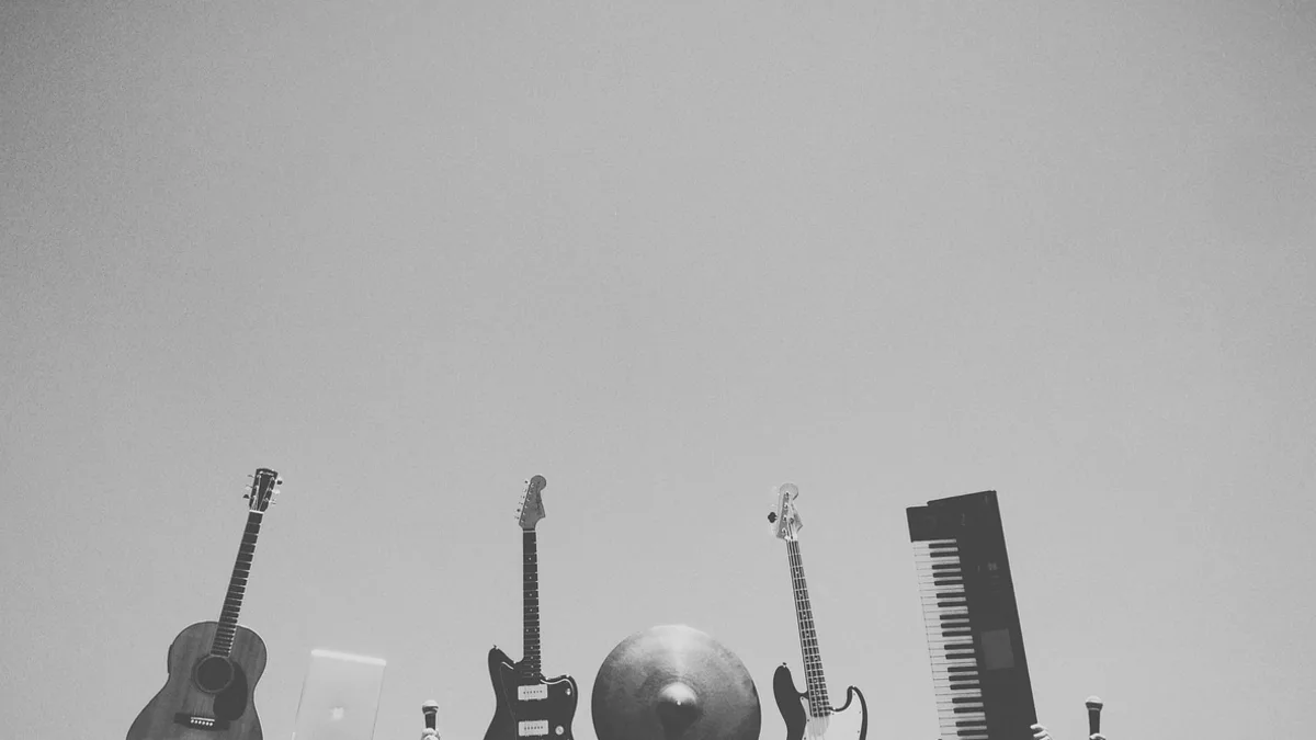 Gitarlar, mikrofon ve bilgisayar bulunan müzik çalışma alanı