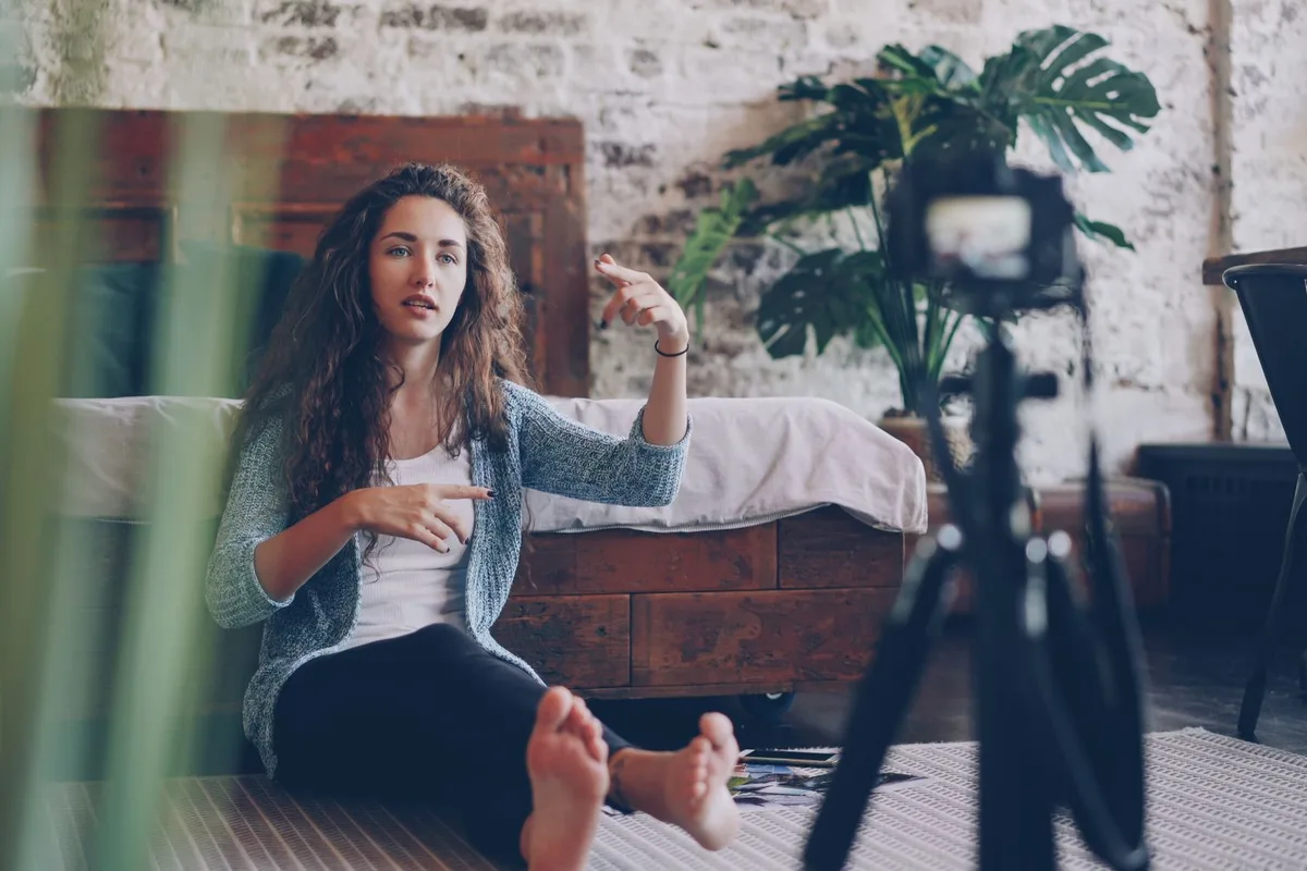 Ev stüdyosunda kamera karşısında video çeken kadın
