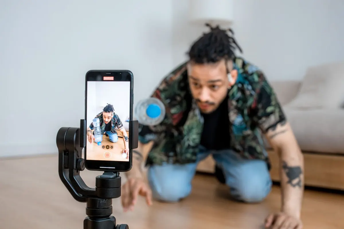 Bir içerik üreticisinin gimbal tripoda bağlı telefonla dikey video çekmesi