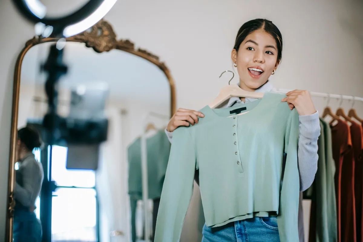 Halka ışık önünde telefonla moda videosu çeken bir kadın