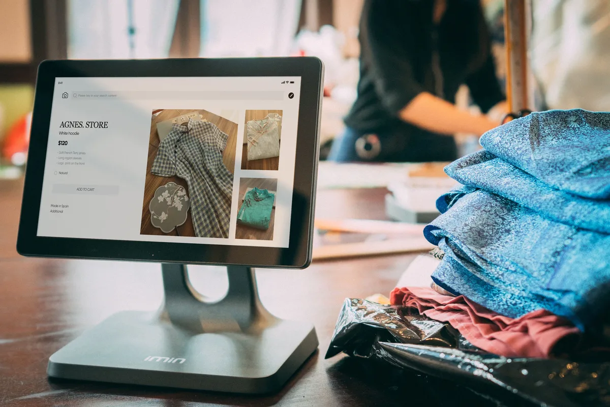 Dijital satış ekranının yanında ürün sergileyen butik