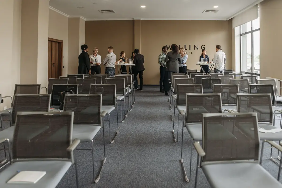 Otel iç mekânında ayakta toplantı yapan ekip