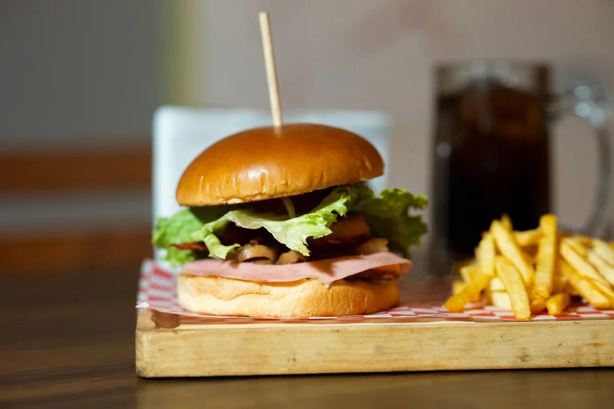 Ahşap servis tahtasında burger ve patates kızartması