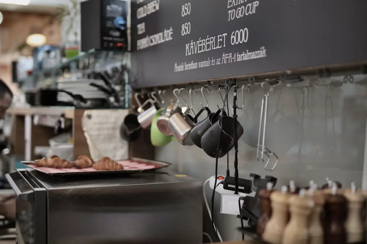 Modern kafe mutfağında duvara asılı metal kupalar